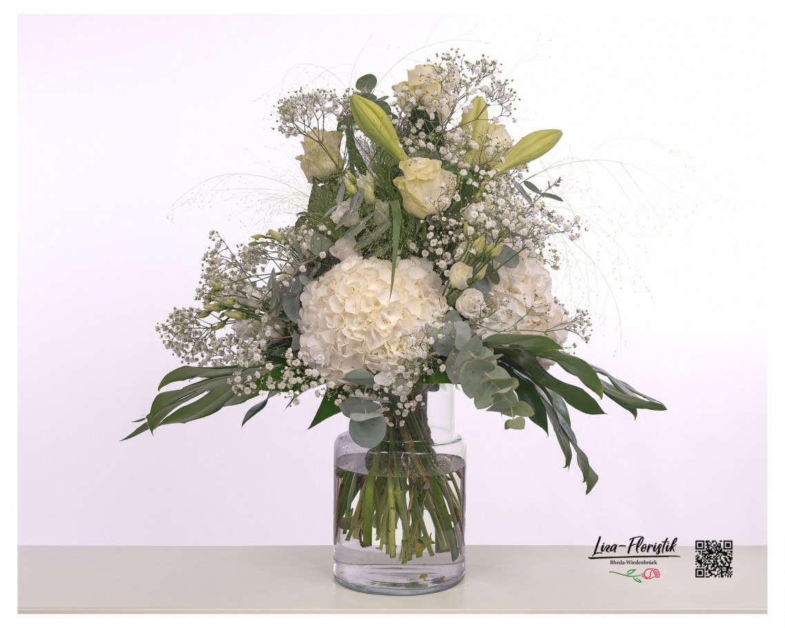 Trauerstrauß mit weißen Hortensien, Eukalyptus, weißem Schleierkraut, weißem Lisianthus, weißen Lilien, Fontaine Gras, Monstera Blättern und weißen Rosen