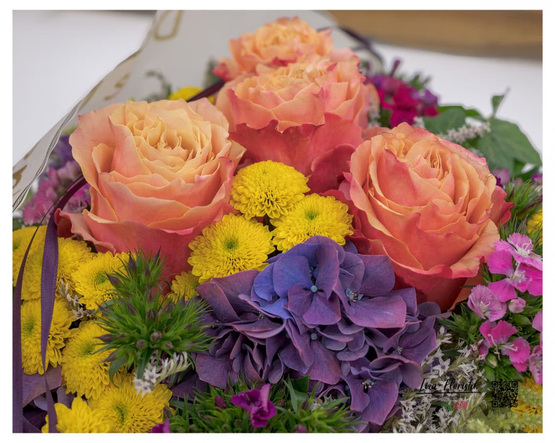 Eine Nahaufnahme des Trauergestecks, das mit leuchtenden Ecuador Rosen, Santini und Hortensien die Schönheit und Vergänglichkeit des Lebens widerspiegelt.