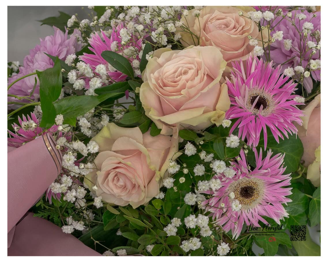 Zartrosa Rosen im Mittelpunkt, kombiniert mit pinken Gerbera, Schleierkraut und Blattgrün