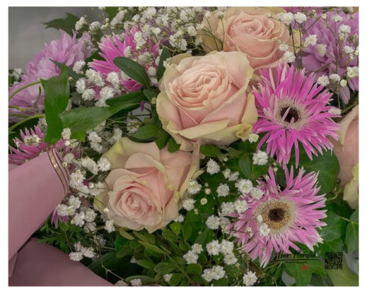 Zartrosa Rosen im Mittelpunkt, kombiniert mit pinken Gerbera, Schleierkraut und Blattgrün