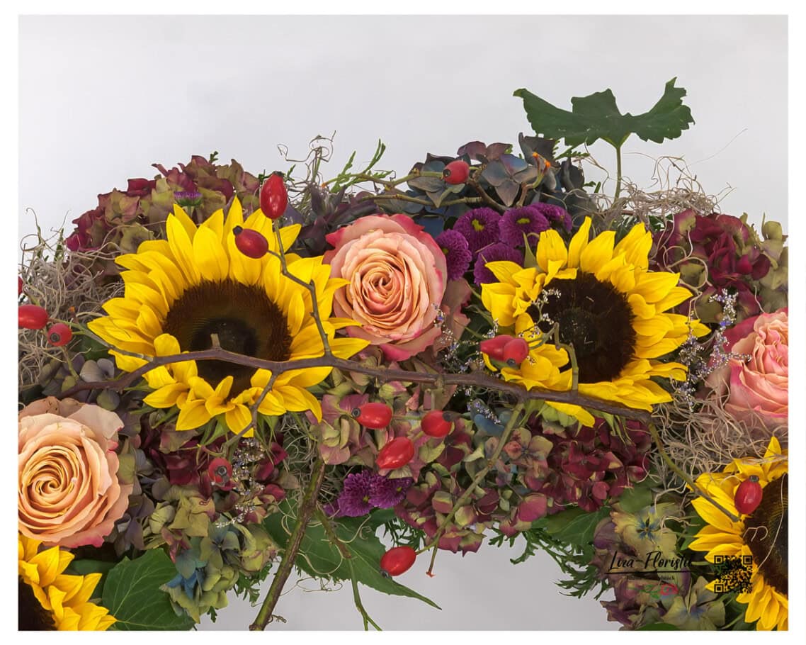 Sonnenblumen und Ecuador Rosen. Details im Trauerkranz