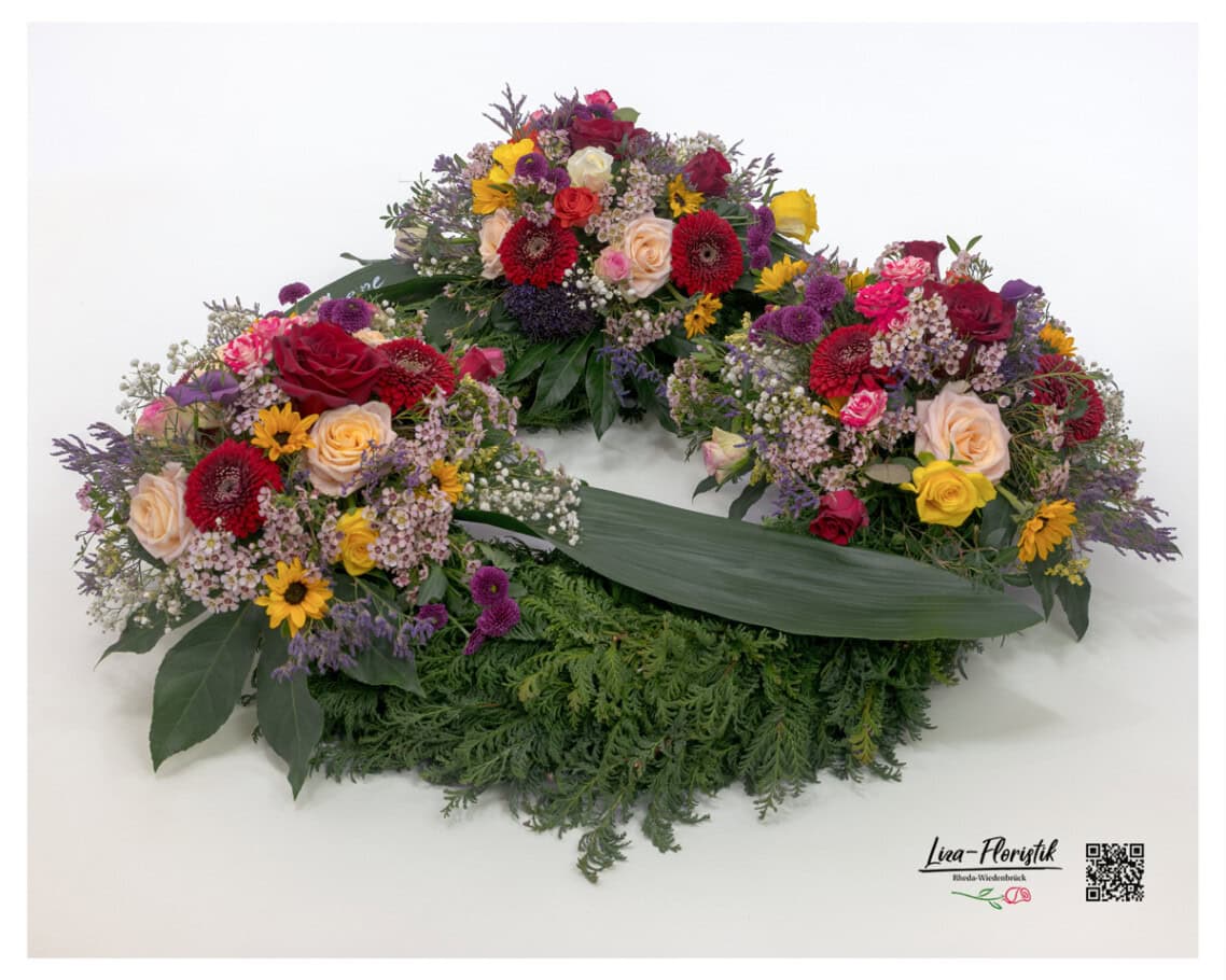 Seitenansicht – offener Trauerkranz mit Bananenblättern, Premium Rosen, Gerbera und Waxflower
